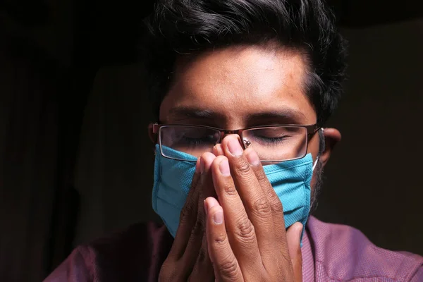 Antivirüs koruması için yüzünde maske olan bir adam dua ediyor. — Stok fotoğraf