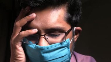 Antivirüs koruması için yüzünde maske olan üzgün bir adam. 