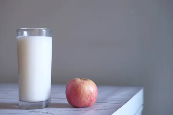 コピースペース付きのテーブルの上に牛乳とリンゴのガラス. — ストック写真