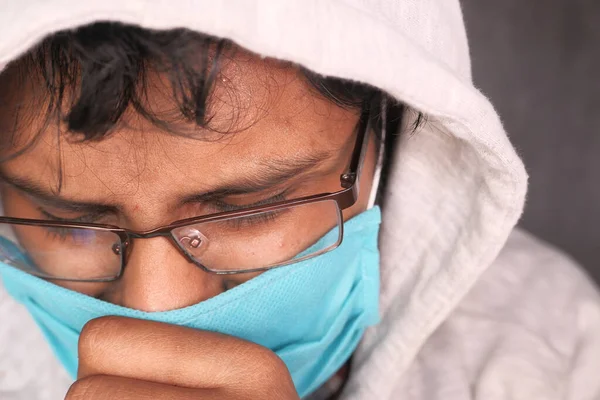 Antivirüs koruması için yüzünde maske olan kapüşonlu hasta bir adam. — Stok fotoğraf