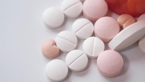 Pilules de couleur débordant du récipient sur isolé sur blanc — Video