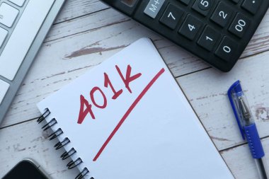 Hesap makinesi kalem ve gözlüklü not defteri üzerine 401k Planı.