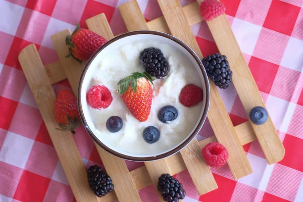 Bowl of fresh mixed berries and yogurt on table — Stock Photo, Image