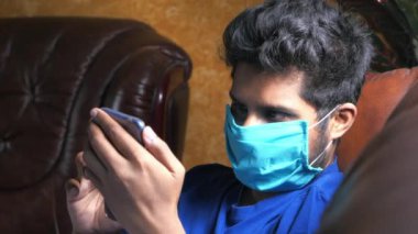 Adam enfeksiyonu önlemek ve akıllı telefon kullanmak için maske takıyor. 