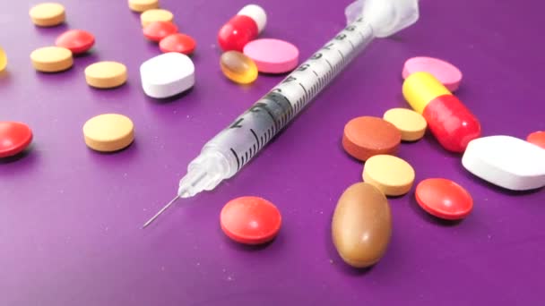 Асортимент медичних препаратів та шприців на кольоровому фоні . — стокове відео