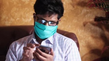 Adam enfeksiyonu önlemek ve akıllı telefon kullanmak için maske takıyor. 
