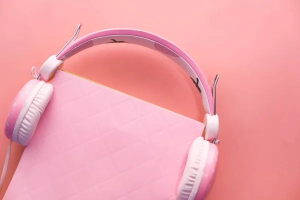 Headphones modernos com livro de capa dura sobre fundo rosa . — Fotografia de Stock