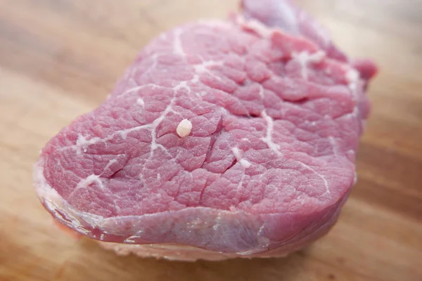 Carne crua, bife de vaca no fundo de madeira . — Fotografia de Stock