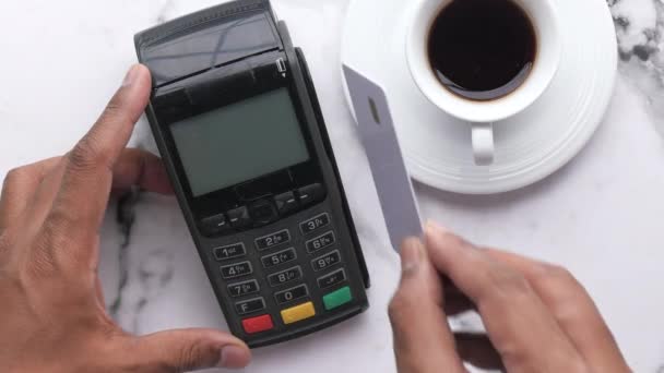 Ο άνθρωπος κρατά στο χέρι μια πιστωτική κάρτα μπροστά από το τερματικό — Αρχείο Βίντεο