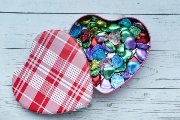 Close up of candy in a heart shape box on table. — Stock Photo, Image