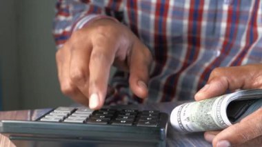 Masadaki hesap makinesi ve finansal grafiği kullanarak bir adamın elini kapat 