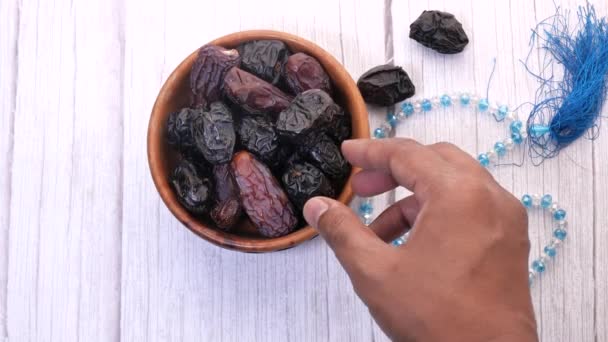 Tangan seorang pria mengambil buah tanggal di piring — Stok Video