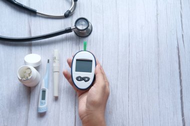 Diyabetik ölçüm araçları tutan kadınların yüksek açılı görünümü 