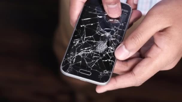 Close-up van de man hand houden gebroken smartphone. — Stockvideo