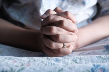 Bir kadının elleri diğerinin üzerine katlandı..