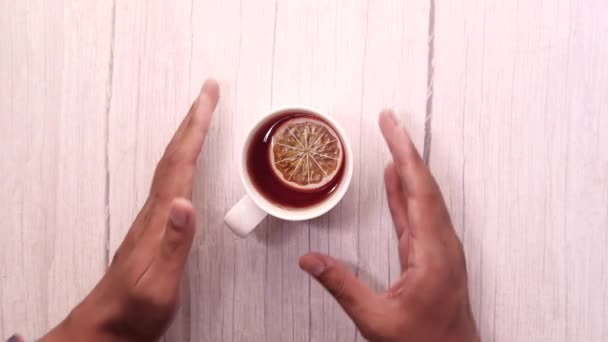 Vista dall'alto dell'uomo che tiene in mano la tazza di tè sul tavolo — Video Stock