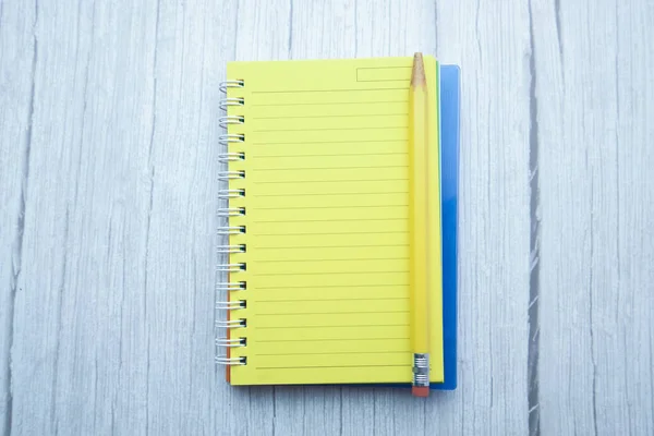 High angle view of notepad and pencil on wooden table. — Stock Photo, Image