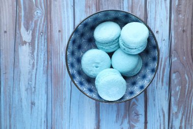 Tahta masadaki bir kasenin üstündeki badem kurabiyesi manzarası. 