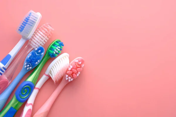 Cepillos de dientes multicolor fondo rosa, vista superior — Foto de Stock