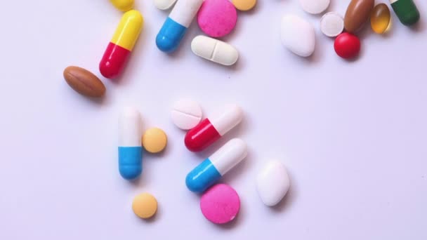 Close-up de comprimidos e cápsulas derramamento recipiente formulário sobre fundo branco — Vídeo de Stock