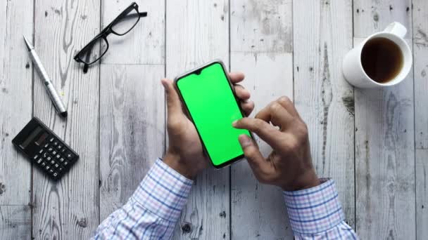 Hombre sosteniendo teléfono inteligente con pantalla vacía, vista de ángulo alto — Vídeos de Stock