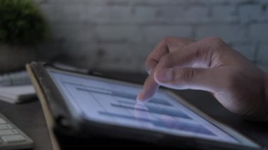 Dijital tabletteki mali verileri analiz eden kişi 