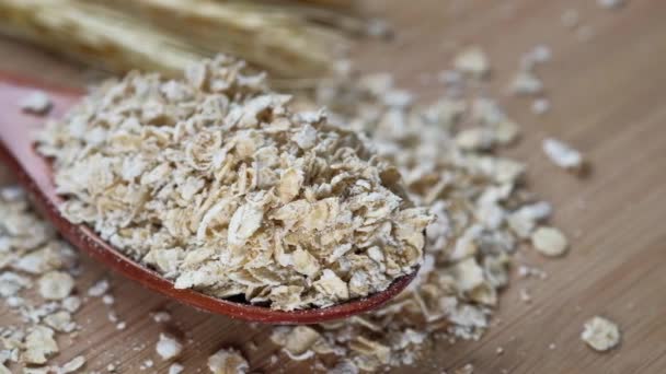 Vista de ángulo alto de copos de avena en cuchara en la mesa — Vídeos de Stock