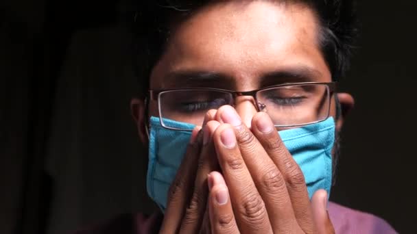 Un hombre enfermo con una máscara en la cara rezando — Vídeos de Stock