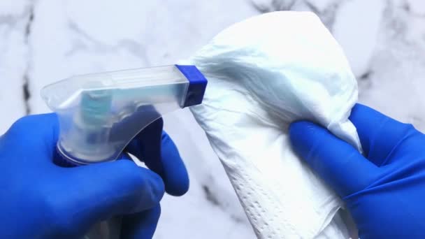 Mano en guantes de goma azul que sostiene la botella del aerosol — Vídeo de stock