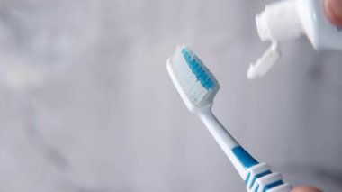 Diş fırçasına diş macunu sıkan genç adam..