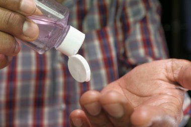 Adam virüsü önlemek için el dezenfektanı kullanıyor. 