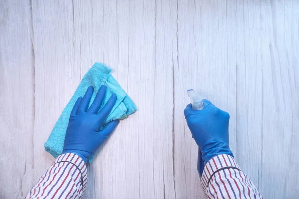 Mano en guantes de goma azul que sostiene la botella del aerosol —  Fotos de Stock