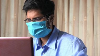 Koruyucu maskeli iş adamı çalışıyor.