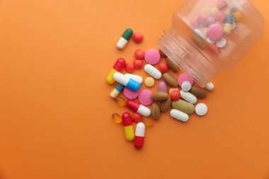 Turuncu arka planda renkli haplar. 