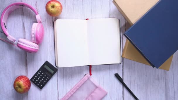 Livros, mochila, artigos de papelaria para estudo em um fundo de madeira . — Vídeo de Stock