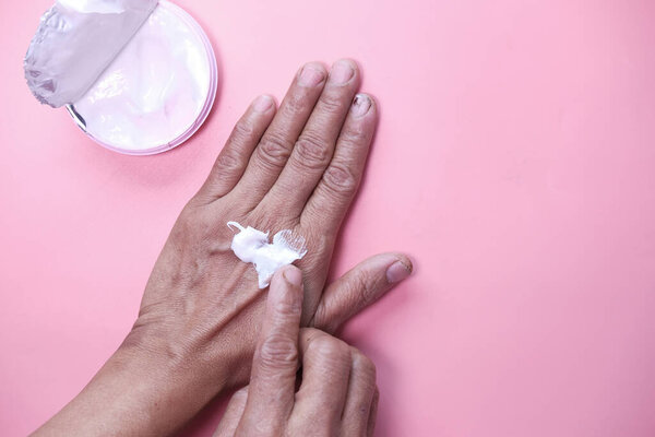 Senior woman applying hand cream, closeup