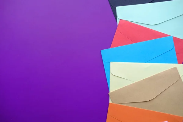 Visão de alto ângulo de envelopes coloridos fundo roxo — Fotografia de Stock
