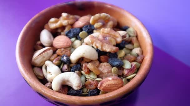 Mixed nuts in a bowls on color background . — Stock Video