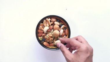 Adam kaseden karışık fındık alıyor. 