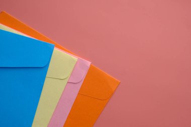 Renkli zarfların yüksek açılı görünümü mor arkaplan 