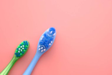 Pembe arkaplanda diş fırçasının üst görünümü.