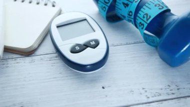  Kan şekeri ölçüm kitleri, dambıl ve pembe üzerine not defteri. 