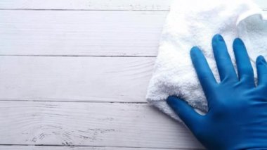 Mavi lastik bir eldiven verin, tahta bir masaya silin.
