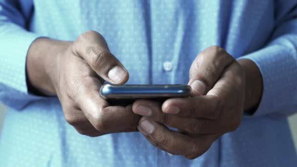 Primer plano de la mano del hombre joven usando el teléfono inteligente — Vídeo de stock