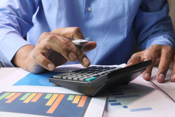 Person hand using calculator on offie desk. Stock Image