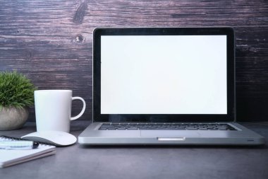Ofis masasında beyaz ekranlı dizüstü bilgisayar