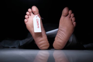 Morgda beyaz giysinin altında, üzerinde boş etiket olan ölü bir adam cesedi.