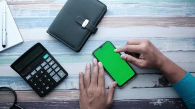 İş adamı boş ekran ve yüksek açı görünümlü akıllı telefon kullanıyor 
