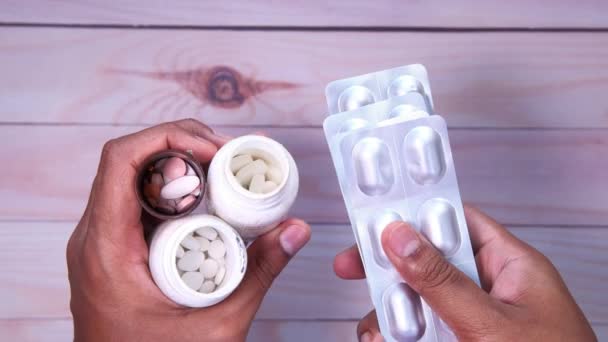 Pillenbehälter und Blisterpackung in der Hand — Stockvideo