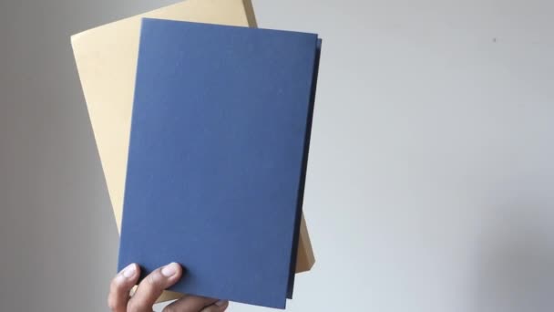 Mano che tiene libri contro un muro . — Video Stock